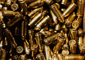 A detailed close-up of scattered brass ammunition bullets in a pile.